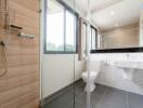 Modern bathroom with glass shower enclosure and large window