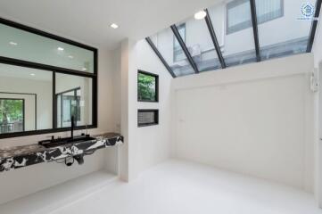 Modern room with large windows and a marble sink