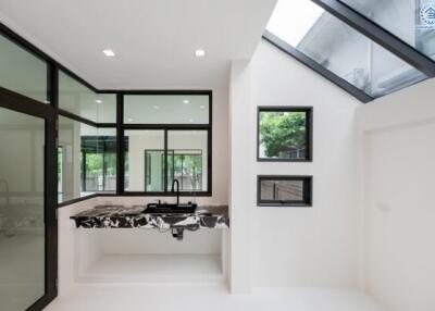 Modern kitchen with marble countertops and large windows