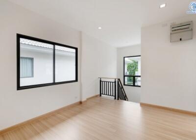 Spacious living area with wooden flooring and large windows