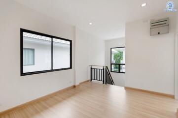 Spacious living area with wooden flooring and large windows