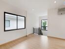 Spacious living area with wooden flooring and large windows