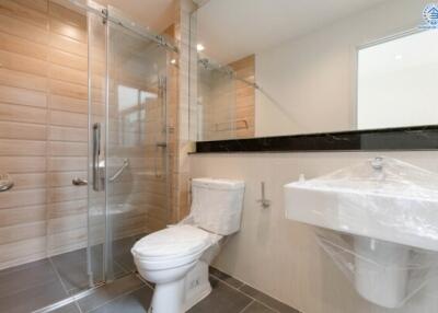 Modern bathroom with glass shower, toilet, and sink