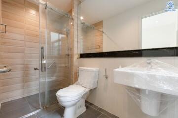 Modern bathroom with glass shower, toilet, and sink