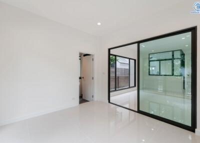 Modern living area with large glass partition and adjoining rooms