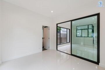 Modern living area with large glass partition and adjoining rooms