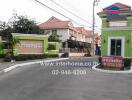 Entrance to residential complex with security booth and house