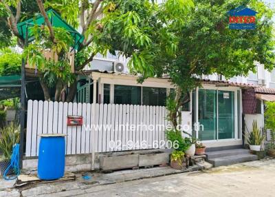 Front exterior view of building with white picket fence and greenery