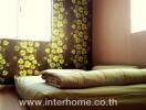 Bedroom with floral wallpaper and foam mattress