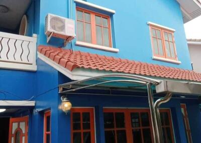 Exterior view of a blue house with red roof tiles