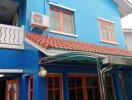 Exterior view of a blue house with red roof tiles