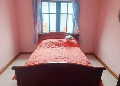 A well-lit bedroom with a window, bed, and fan