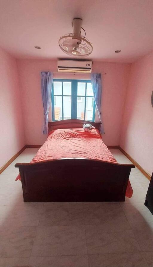 A well-lit bedroom with a window, bed, and fan