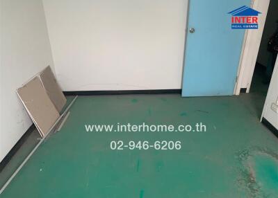 Empty room with green floor and blue door