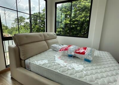 Modern bedroom with large windows and a new mattress