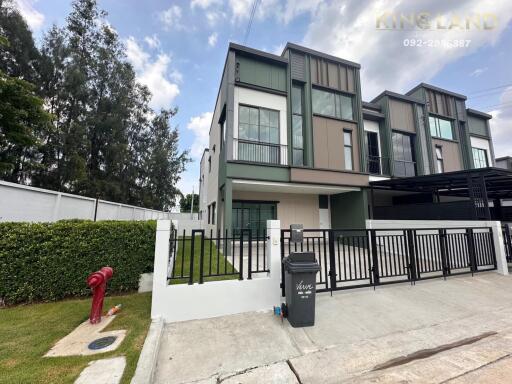 Modern townhouse with multiple floors and a small front yard