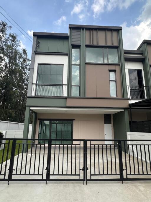 Modern two-story house with large windows and a driveway