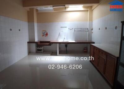 Spacious kitchen with tiled walls and wooden cabinets