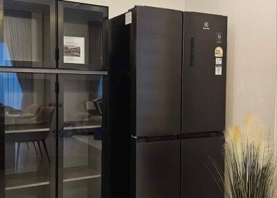 Black refrigerator and glass pantry cabinet