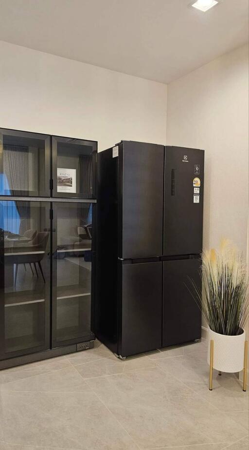 Black refrigerator and glass pantry cabinet