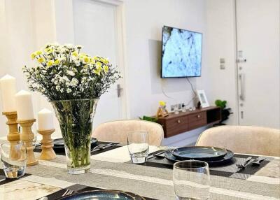 Modern dining area with a set table and a view of the living space