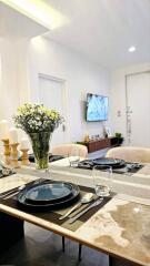 Modern dining area with a set table and a view of the living space