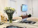 Modern dining area with a set table and a view of the living space