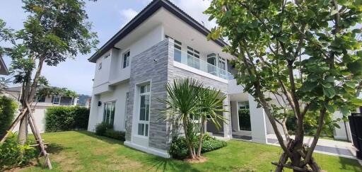 Modern two-story house exterior with garden and trees