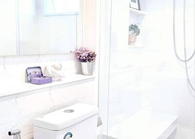 A modern bathroom with white fixtures and decor