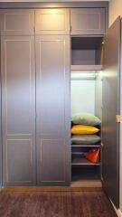 Closet with open door showing shelves and pillows