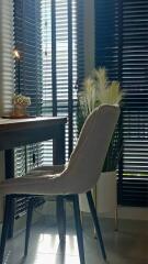 Home office with desk and chair near window with blinds