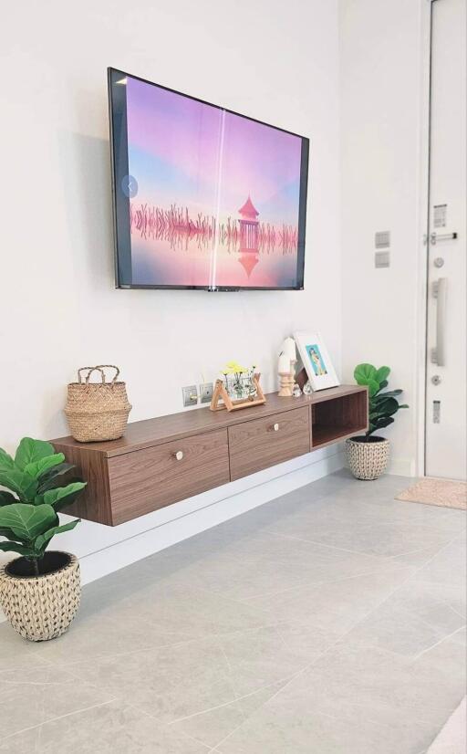 Modern living room with wall-mounted TV and floating wooden shelf