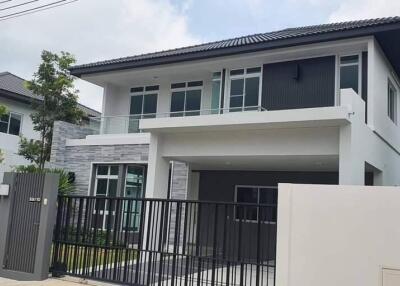 Front view of a modern double-story house with a gated driveway