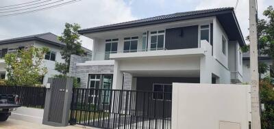 Front view of a modern double-story house with a gated driveway