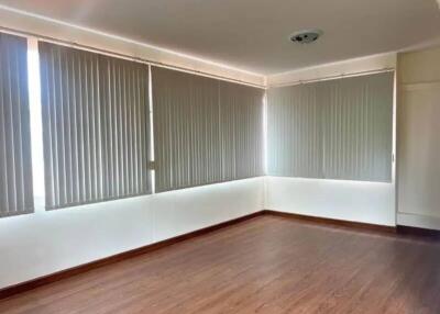 Spacious living room with large windows and blinds