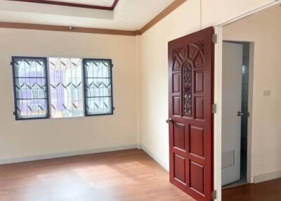 Bedroom with a wooden door and window with decorative grilles