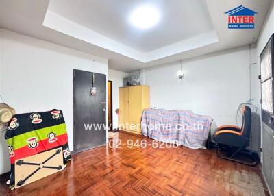 Bedroom with wooden floor, closet, chair, and funky bedspread