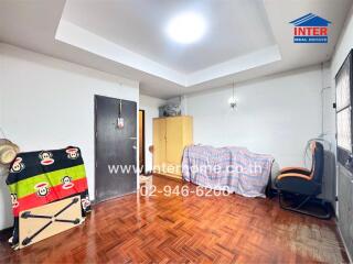 Bedroom with wooden floor, closet, chair, and funky bedspread