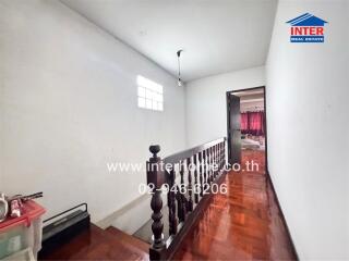 Stairway and hallway with a view into an adjacent room