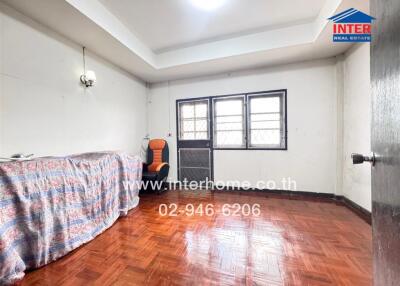 Small bedroom with parquet flooring and simple furnishings