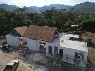 Construction stage of a single-story house with surrounding greenery