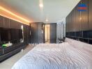 Modern bedroom with a large bed, built-in storage, and a wall-mounted TV