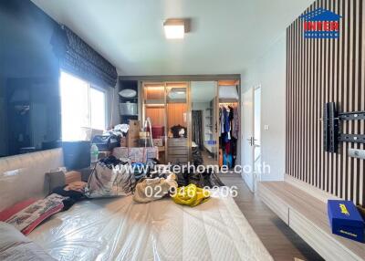 Bedroom with large window, bed, and built-in wardrobe