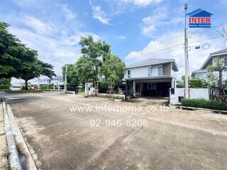 Residential street with white houses and greenery