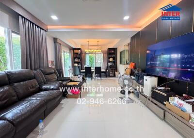 Spacious living room with leather sofa and large television