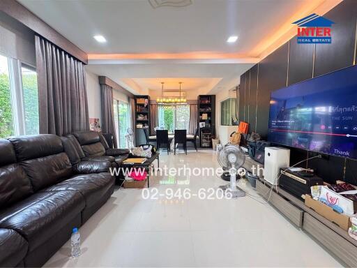 Spacious living room with leather sofa and large television