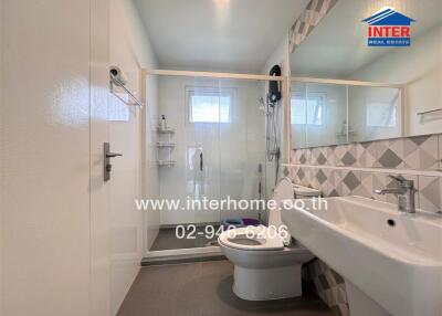 Modern bathroom with glass shower, toilet, and sink