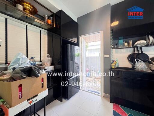 Modern kitchen with black cabinets and a small outdoor area