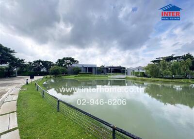 View of the building exterior with a pond and green surroundings