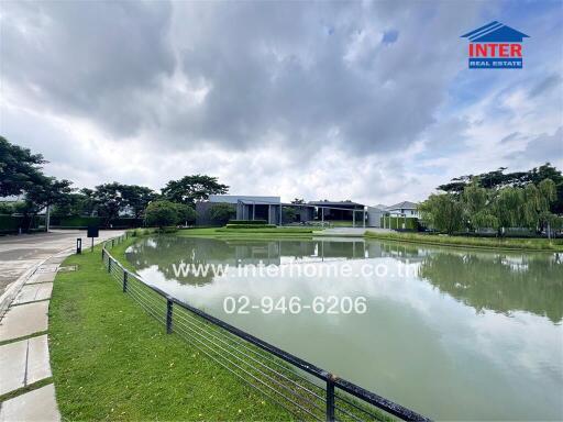 View of the building exterior with a pond and green surroundings